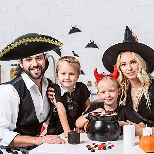 Family in Halloween costumes with candy cauldron.